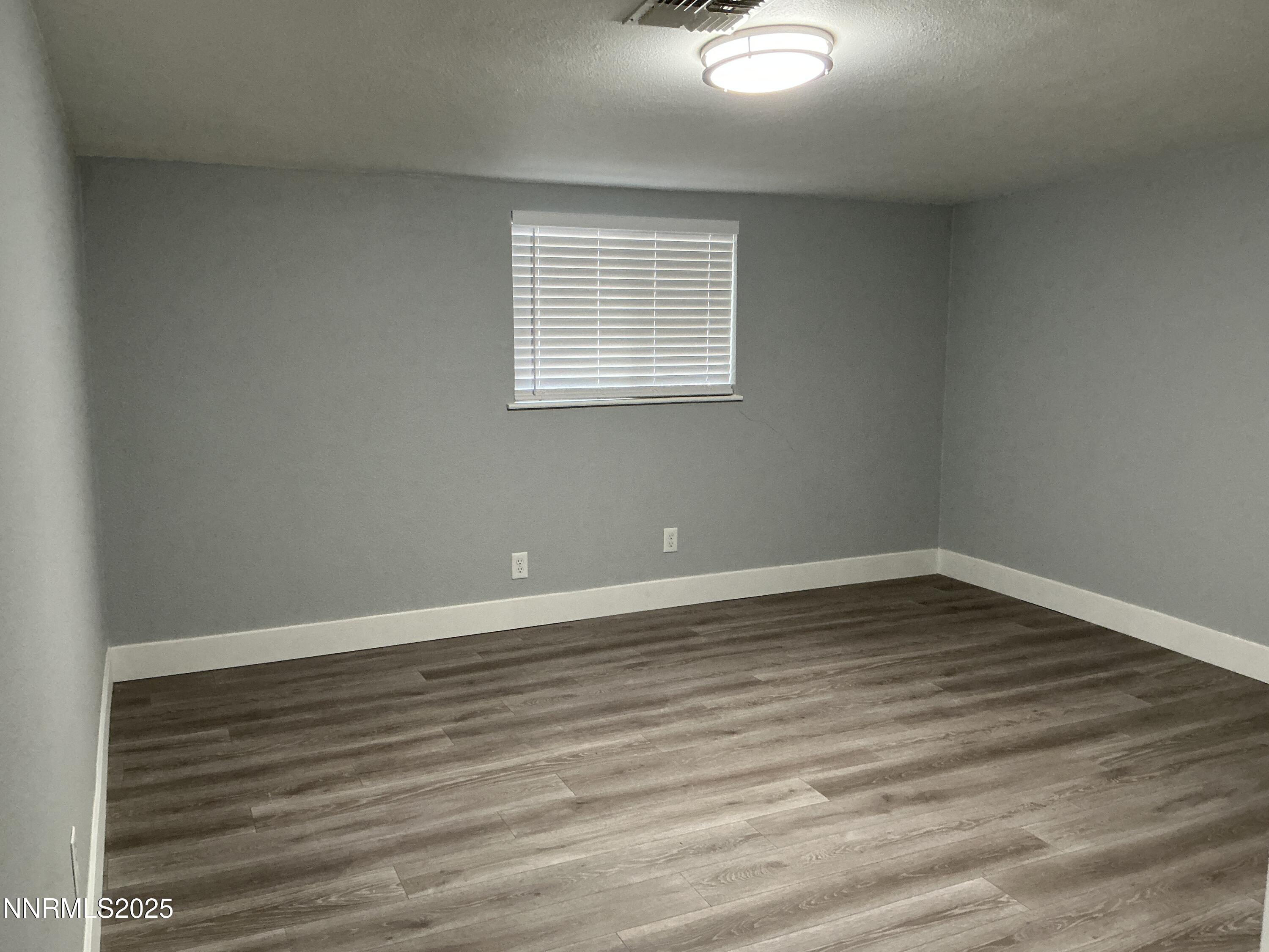 905 Mauldin Lane Reno, NV 89502 - Photo 7 of 21 a view of an empty room with wooden floor and a window