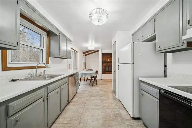 a kitchen with granite countertop a sink appliances cabinets and furniture