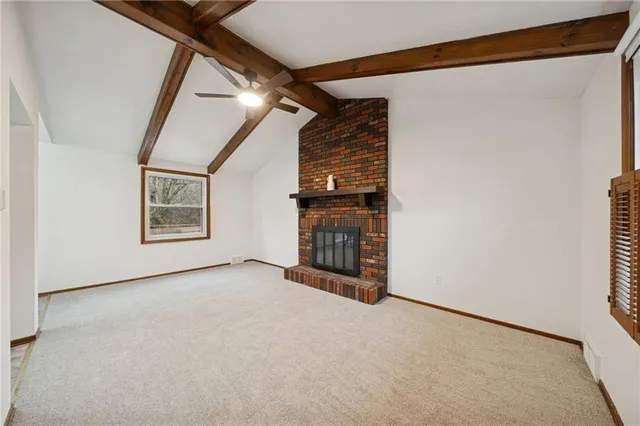 a view of an empty room with a window and brick walls