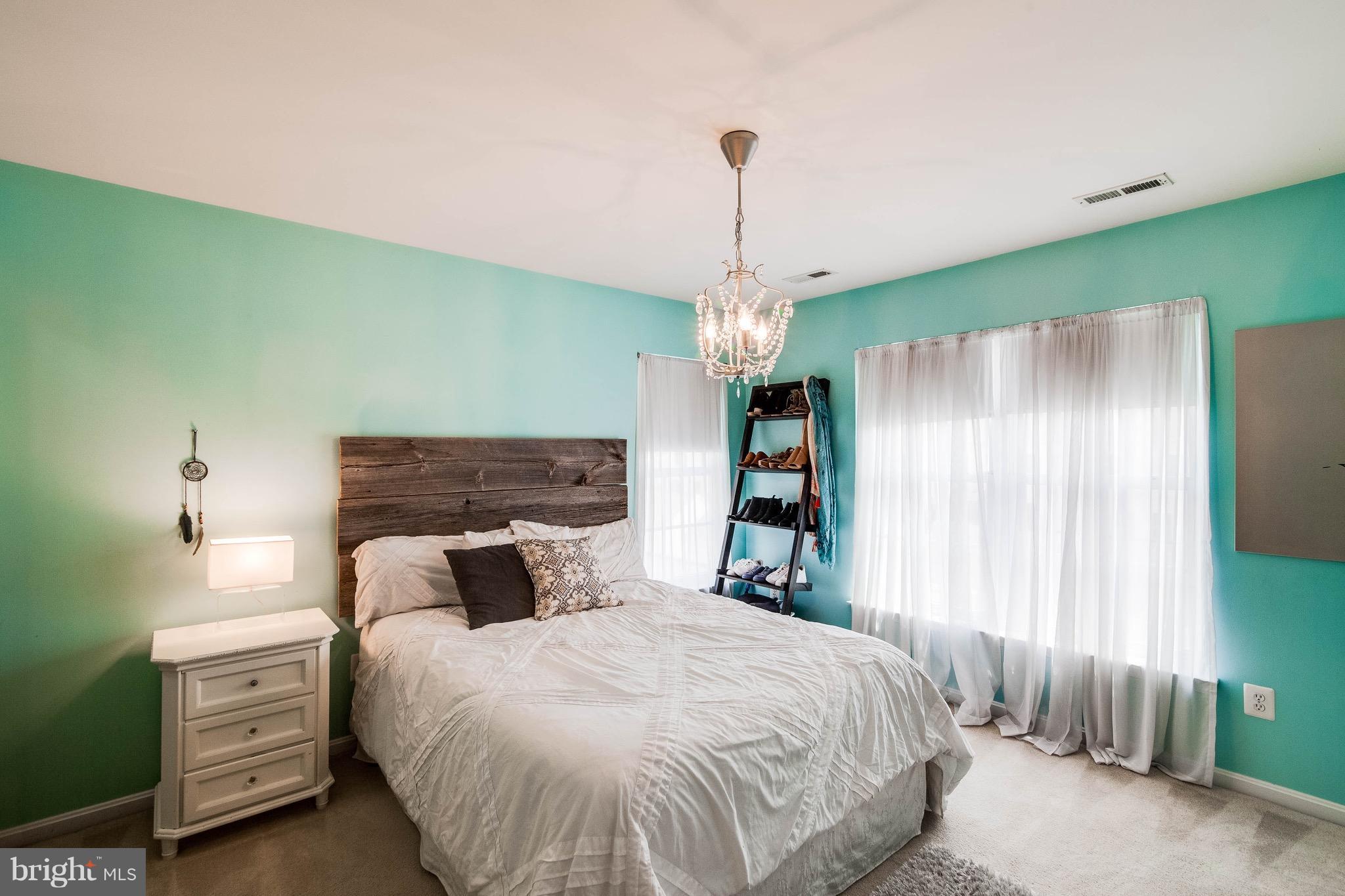 22960 Fanshaw Square Ashburn, VA 20148 - Photo 24 of 30 a bedroom with a bed and a chandelier