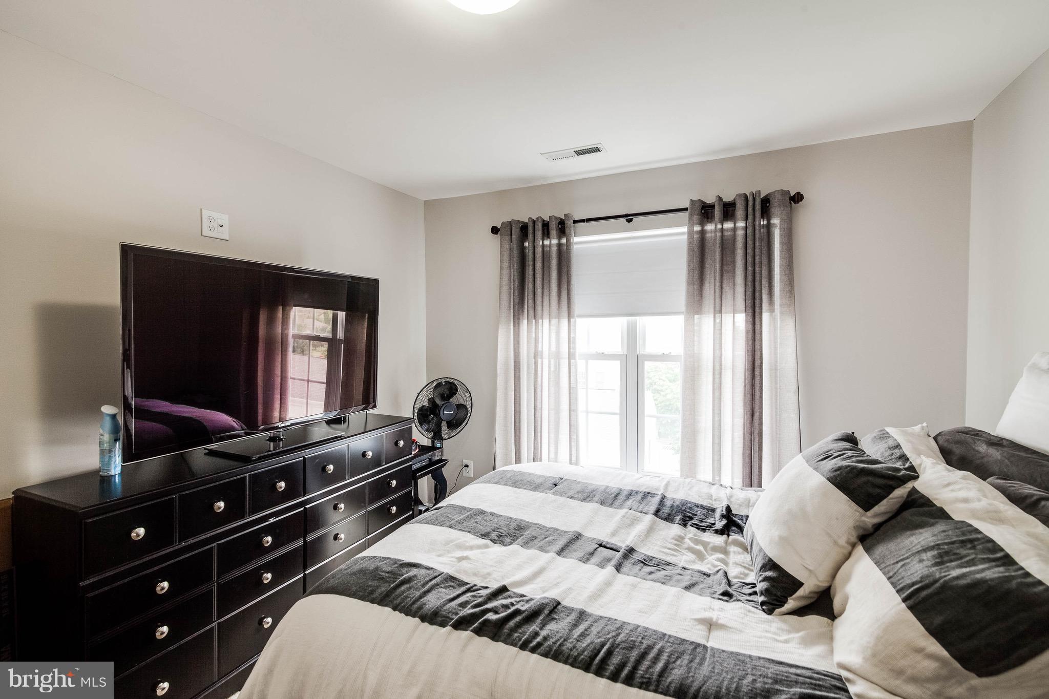 22960 Fanshaw Square Ashburn, VA 20148 - Photo 25 of 30 a bedroom with a bed and a flat tv screen on dresser