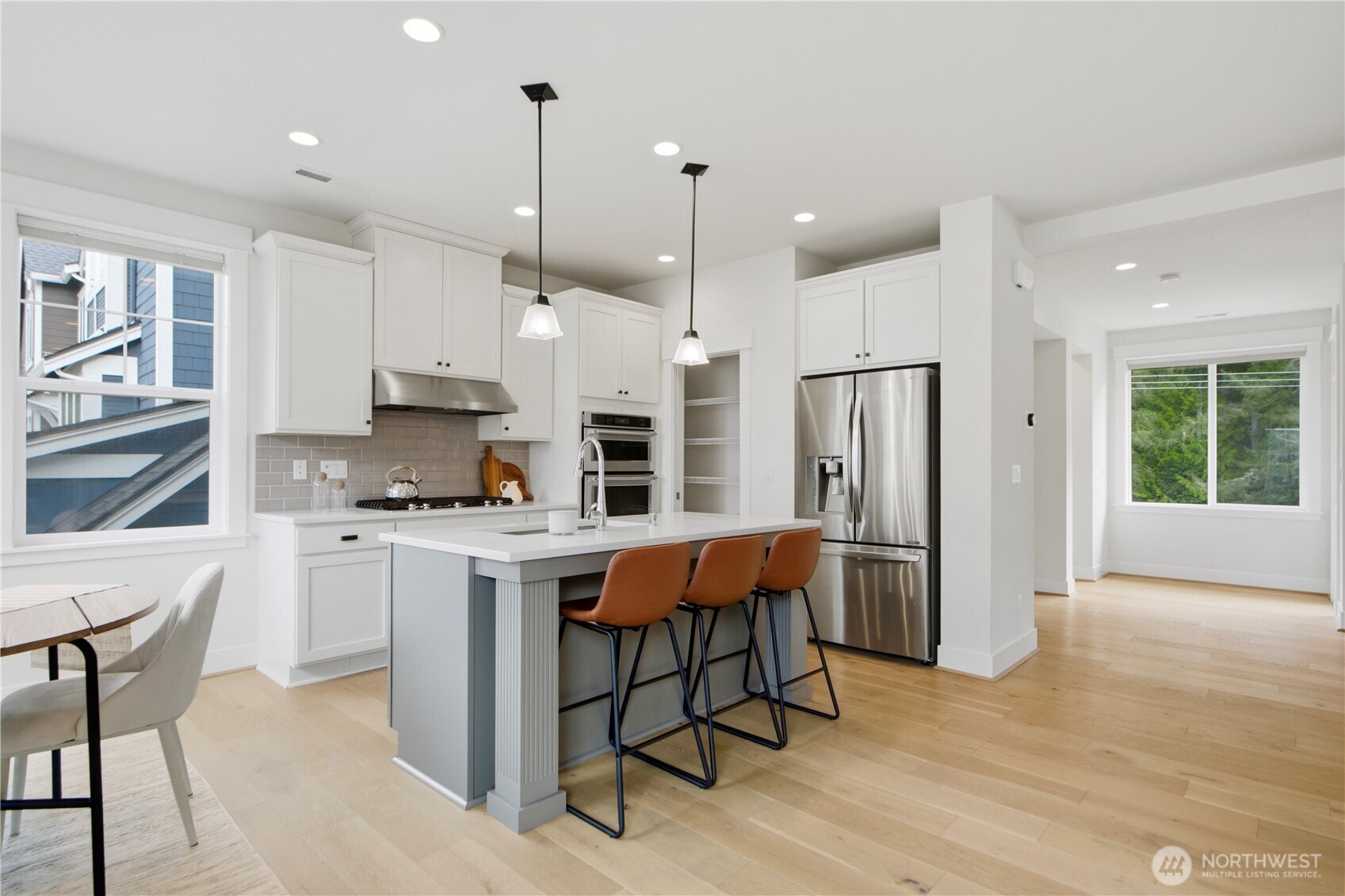 18615 46th Avenue Southeast Bothell, WA 98012 - Photo 7 of 37 a kitchen with stainless steel appliances granite countertop a refrigerator a sink dishwasher a stove and white cabinets with wooden floor