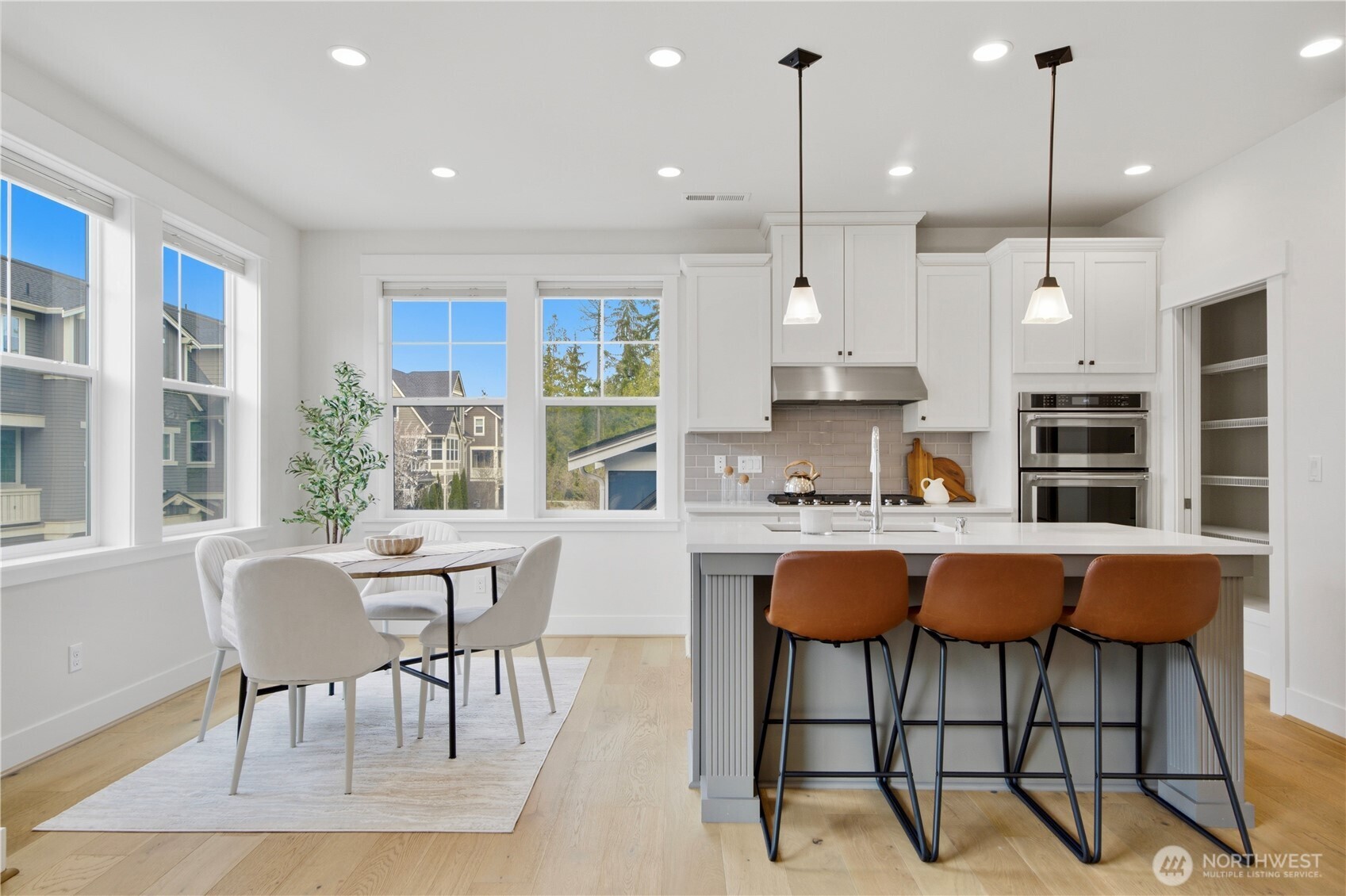18615 46th Avenue Southeast Bothell, WA 98012 - Photo 10 of 37 a kitchen with stainless steel appliances granite countertop a stove a sink a dining table and chairs with wooden floor