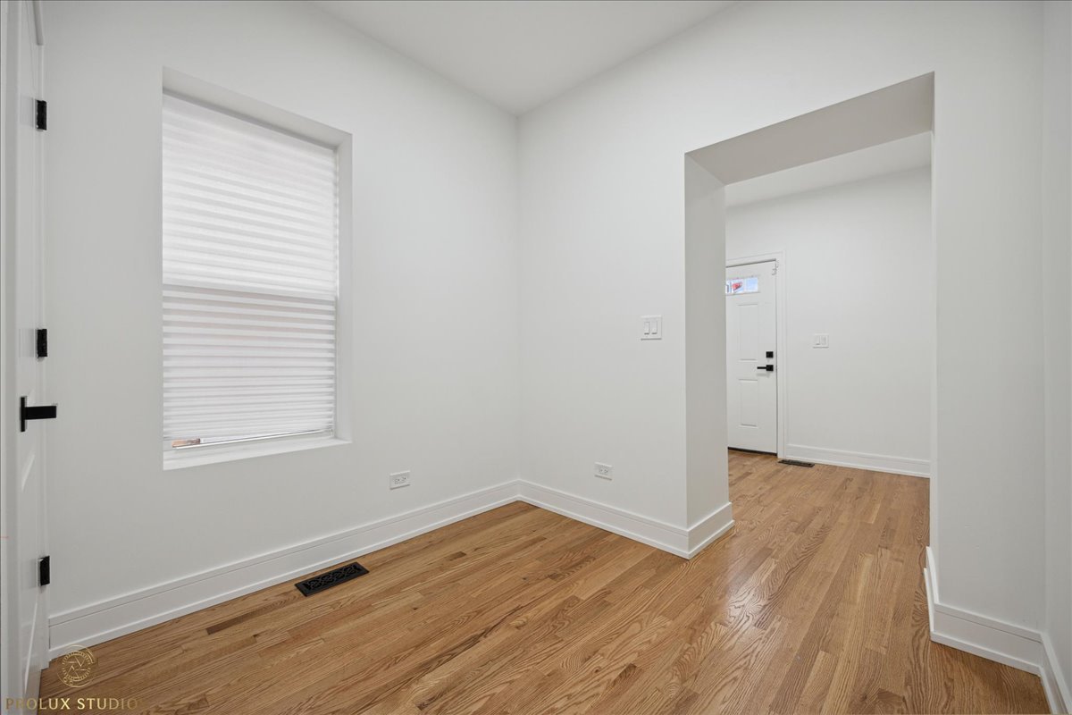 6637 South Marquette Road Chicago, IL 60637 - Photo 11 of 22 an empty room with wooden floor and windows