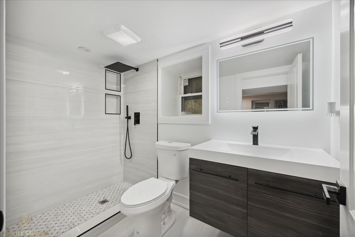 6637 South Marquette Road Chicago, IL 60637 - Photo 16 of 22 a bathroom with a granite countertop toilet sink shower and mirror