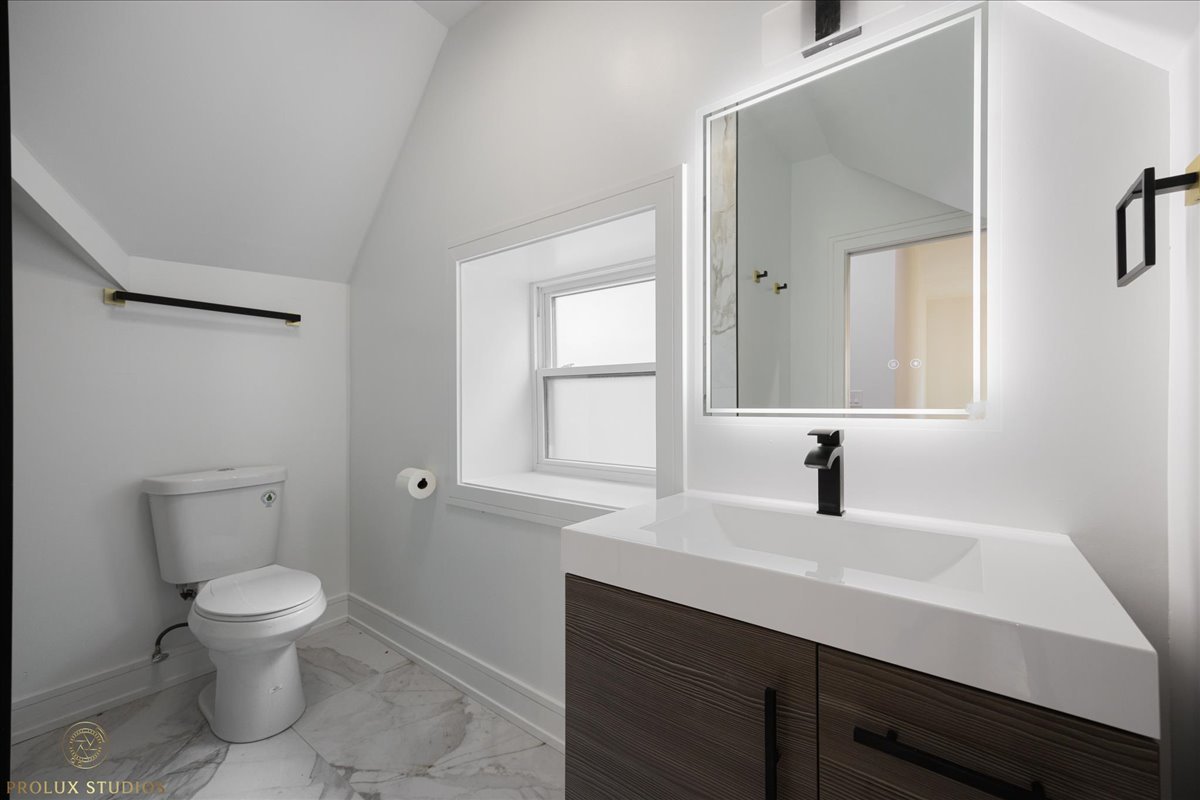 6637 South Marquette Road Chicago, IL 60637 - Photo 19 of 22 a bathroom with a toilet sink a mirror and window