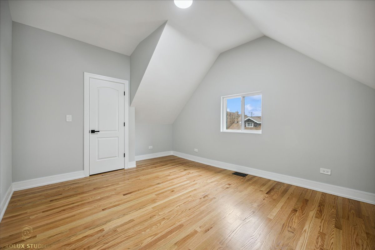 6637 South Marquette Road Chicago, IL 60637 - Photo 21 of 22 an empty room with wooden floor and windows