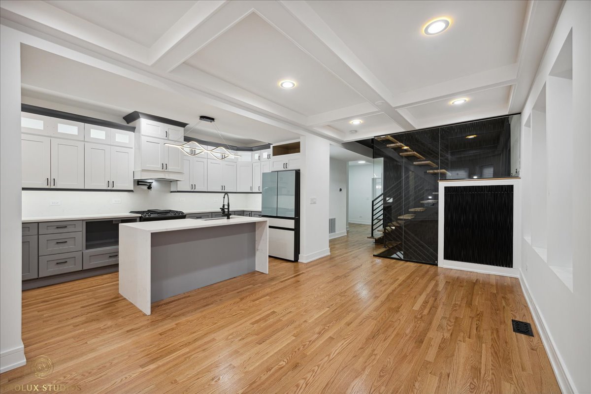 6637 South Marquette Road Chicago, IL 60637 - Photo 4 of 22 a large white kitchen with wooden floors and stainless steel appliances