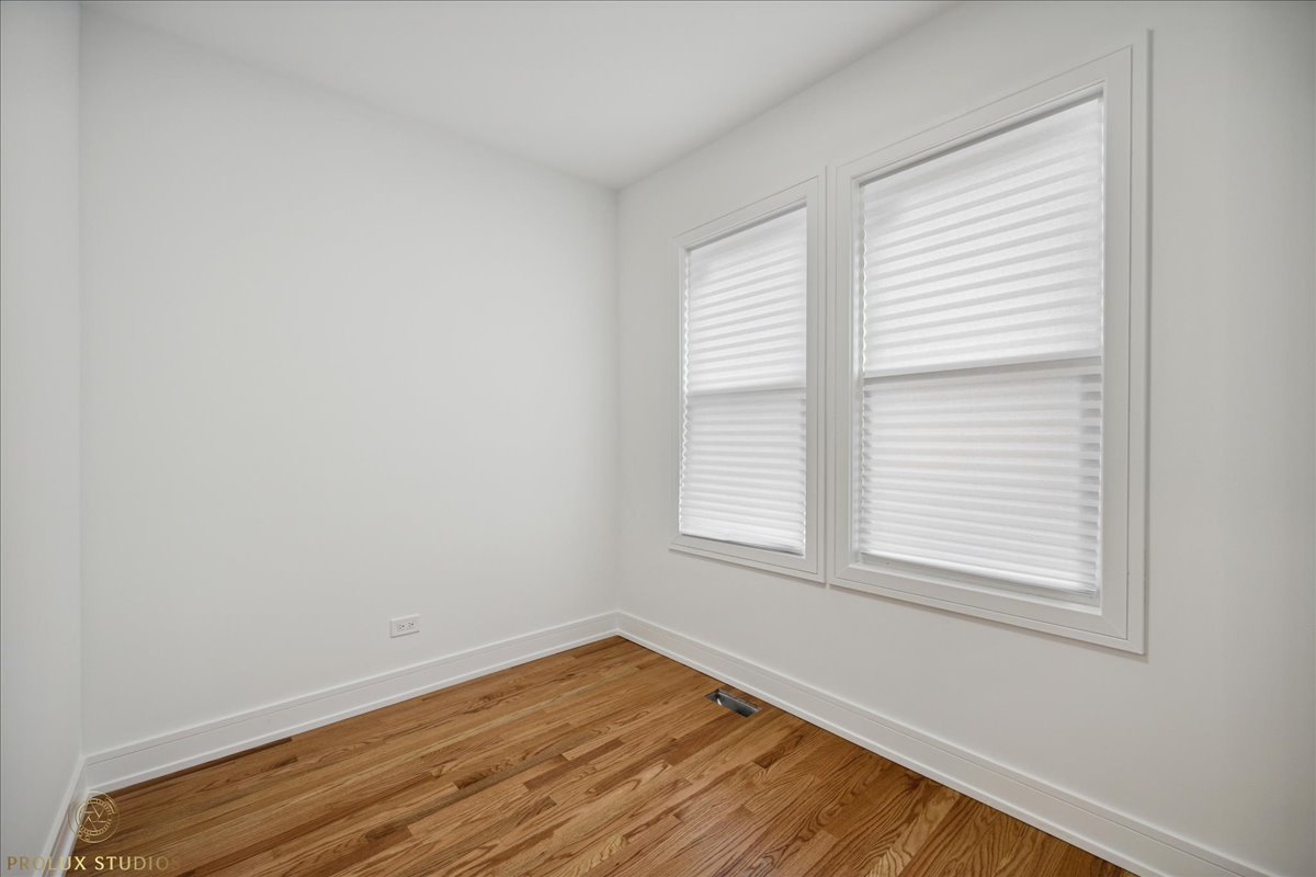 6637 South Marquette Road Chicago, IL 60637 - Photo 9 of 22 an empty room with wooden floor and windows