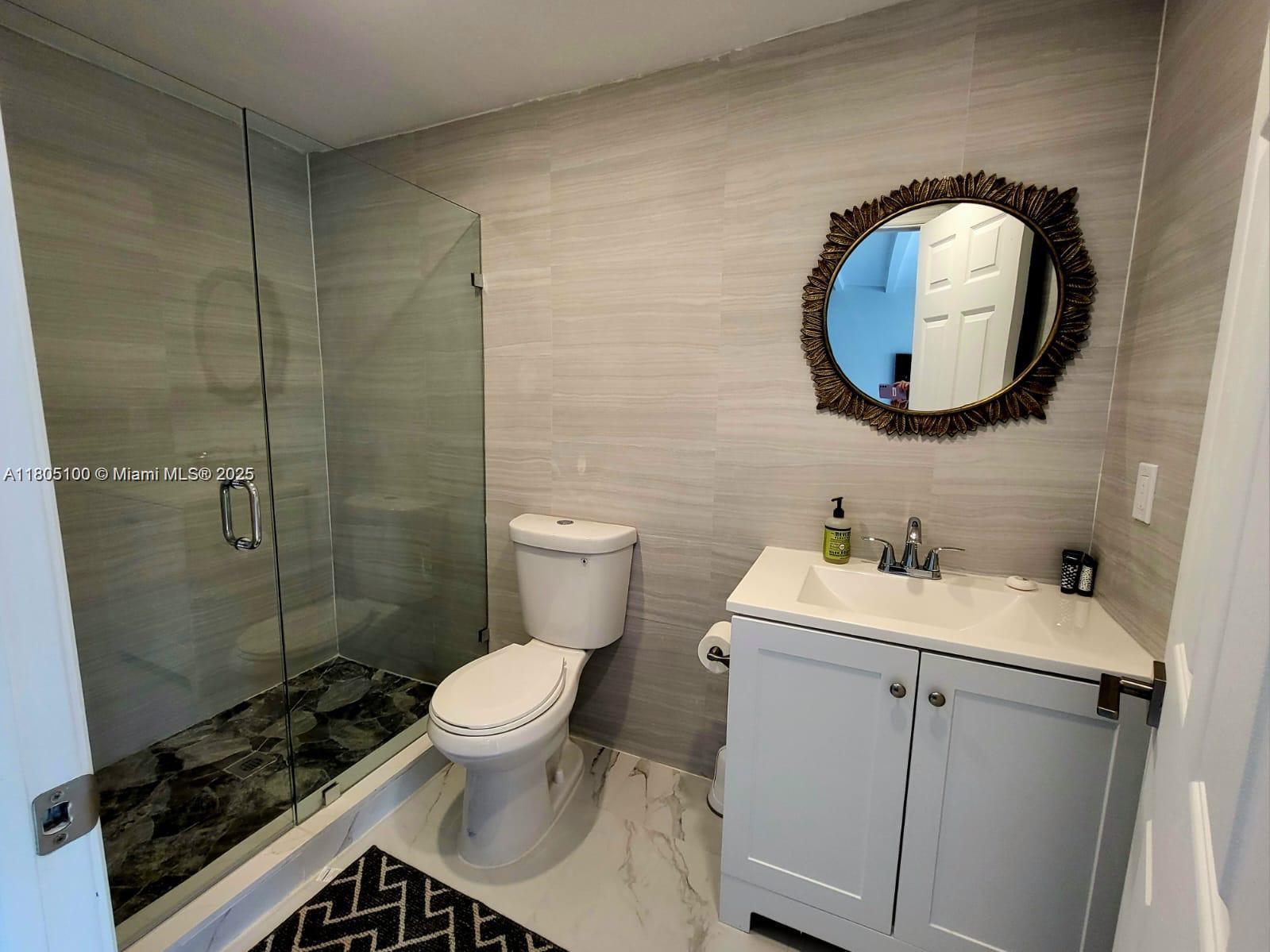 900 Southwest 31st Street Fort Lauderdale, FL 33315 - Photo 5 of 14 a bathroom with a toilet sink vanity and mirror