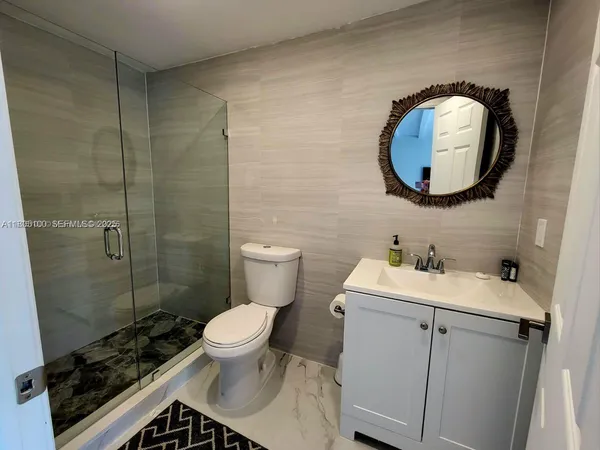 a bathroom with a toilet sink vanity and mirror