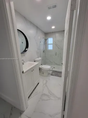 a bathroom with a toilet sink and mirror