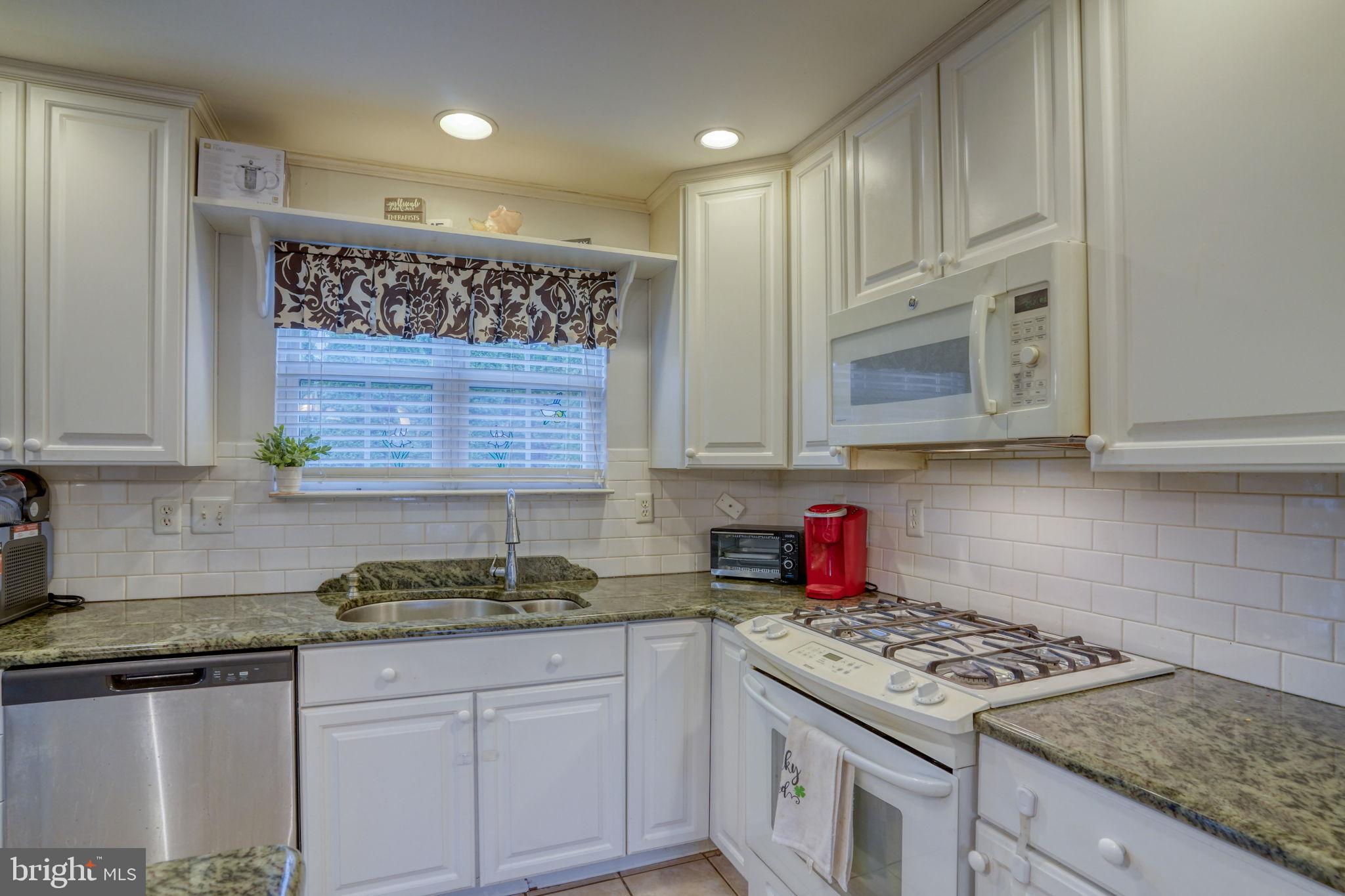 12 Bancroft Road New Castle, DE 19720 - Photo 11 of 38 a kitchen with stainless steel appliances granite countertop a stove a sink and a white cabinets