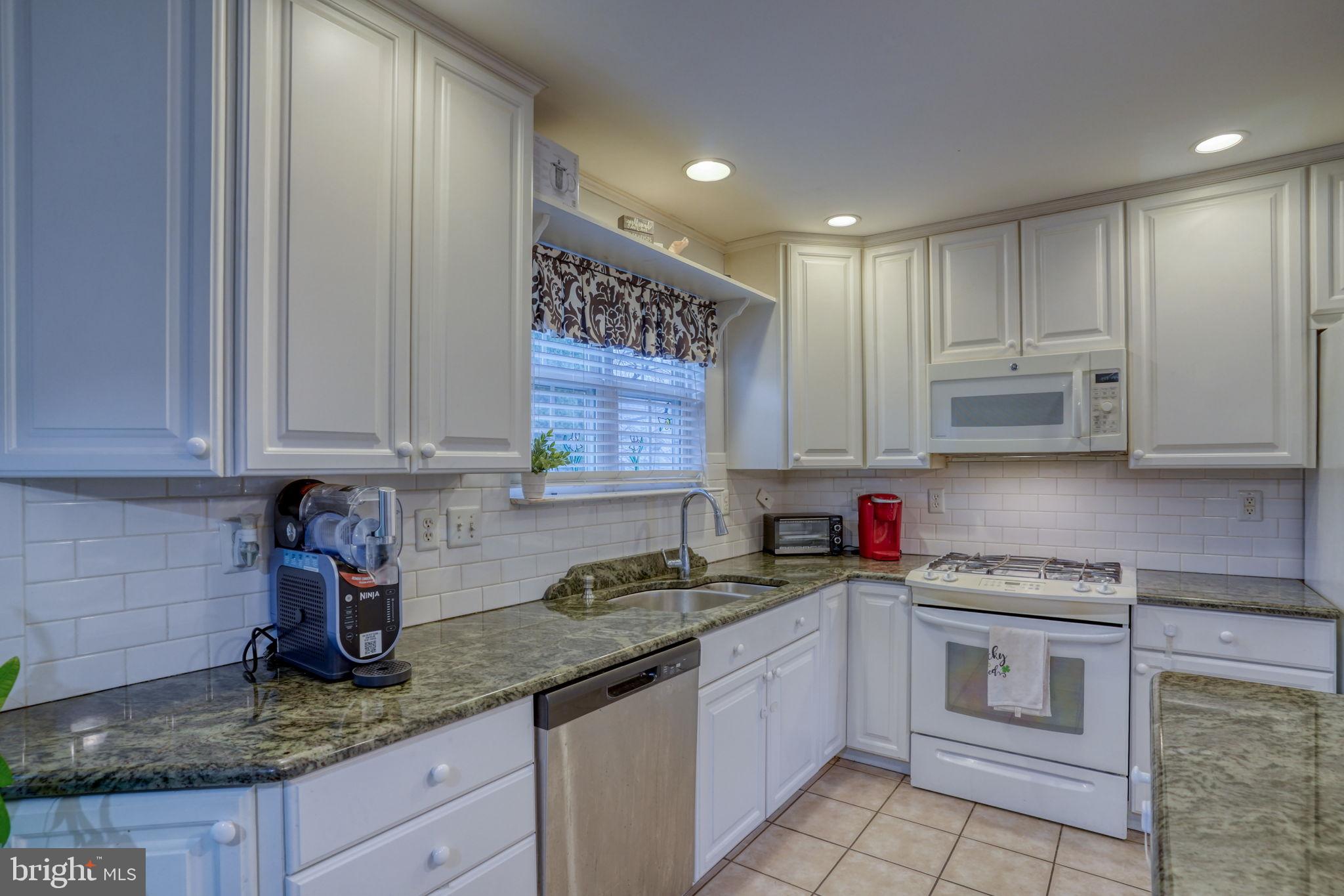12 Bancroft Road New Castle, DE 19720 - Photo 14 of 38 a kitchen with stainless steel appliances granite countertop a sink stove and cabinets