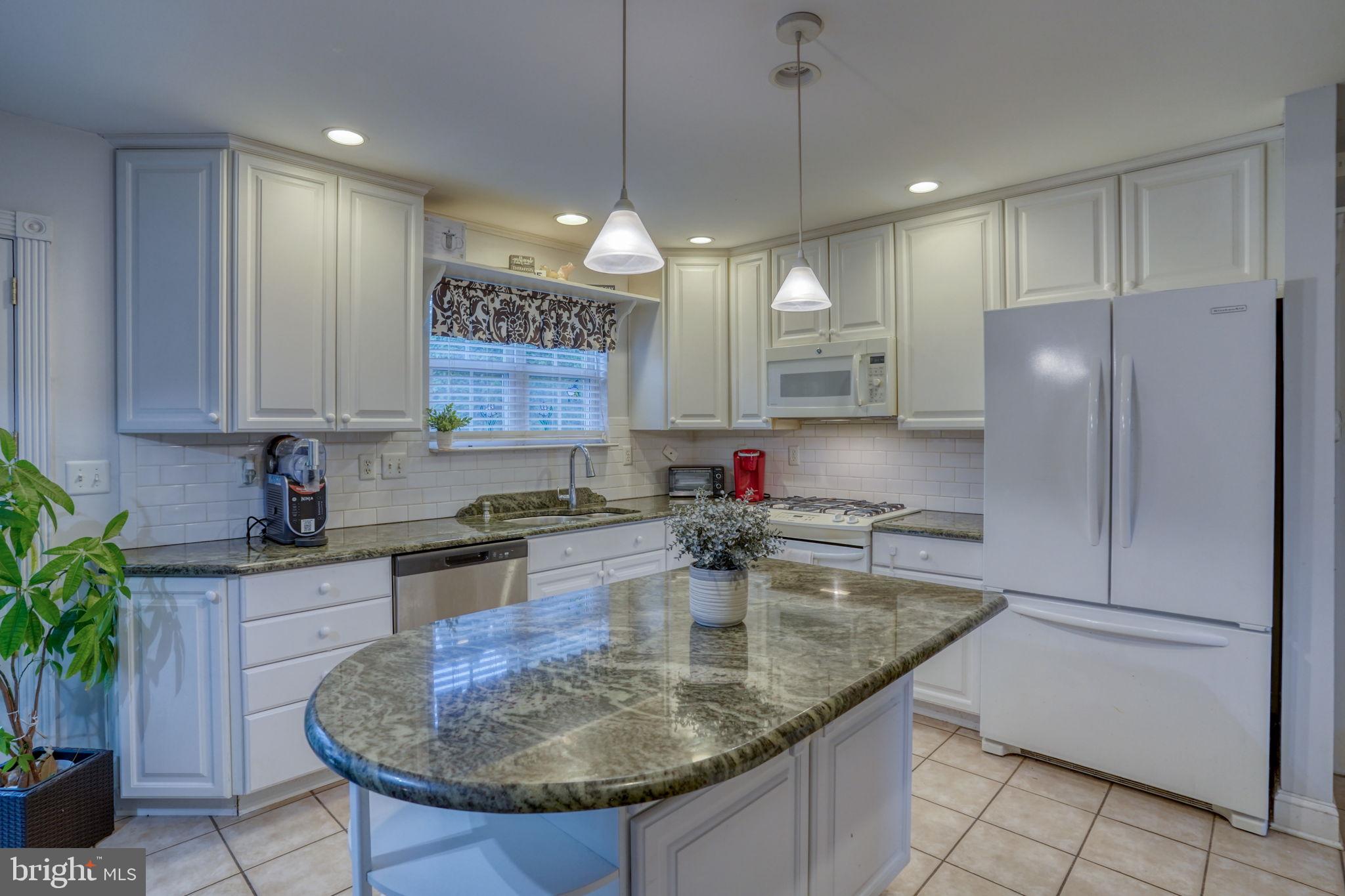 12 Bancroft Road New Castle, DE 19720 - Photo 15 of 38 a kitchen with stainless steel appliances granite countertop a sink refrigerator and cabinets