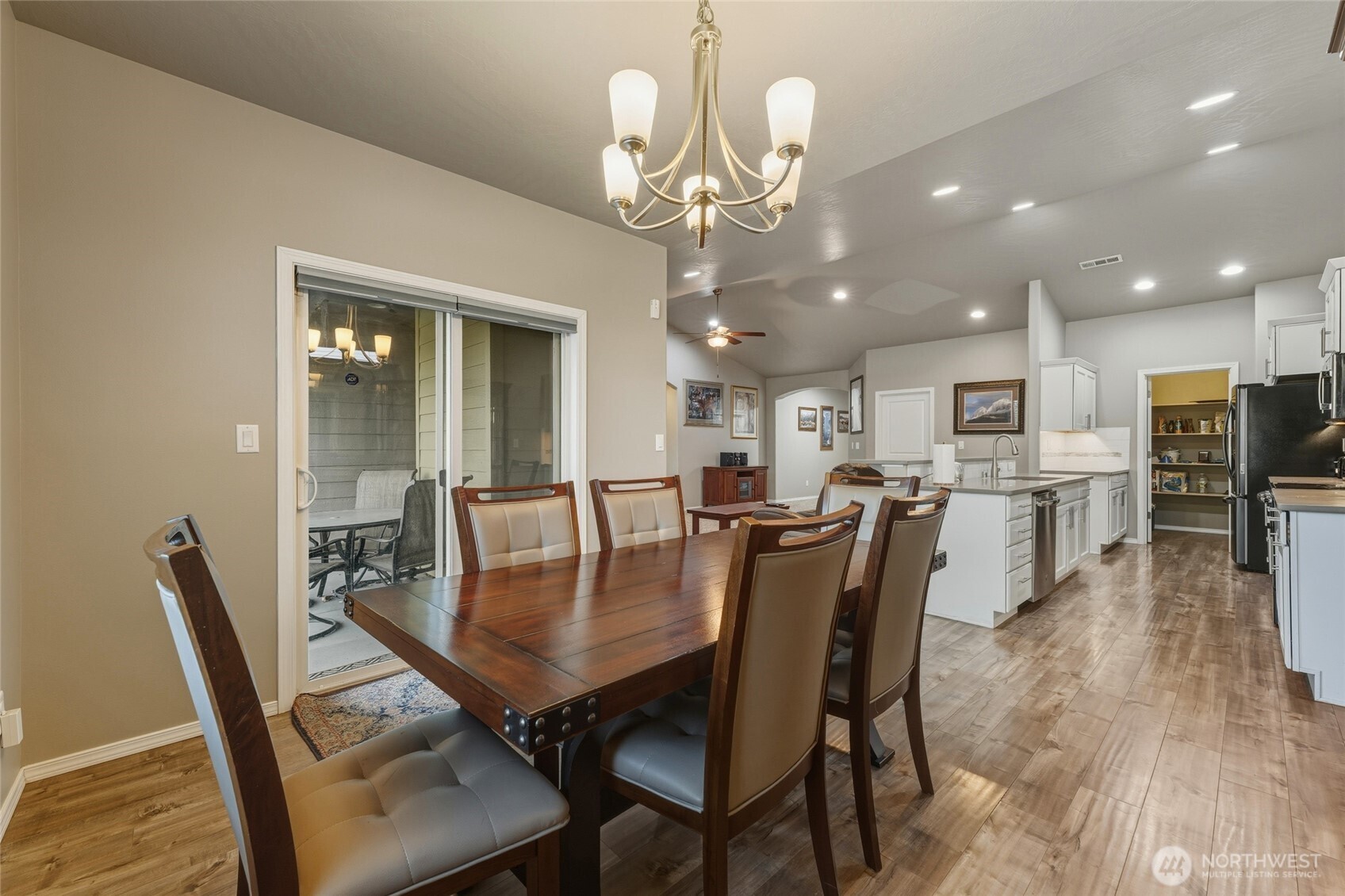 1397 Caprio Loop Walla Walla, WA 99362 - Photo 23 of 40 a dining room with wooden floor a chandelier a wooden table and chairs