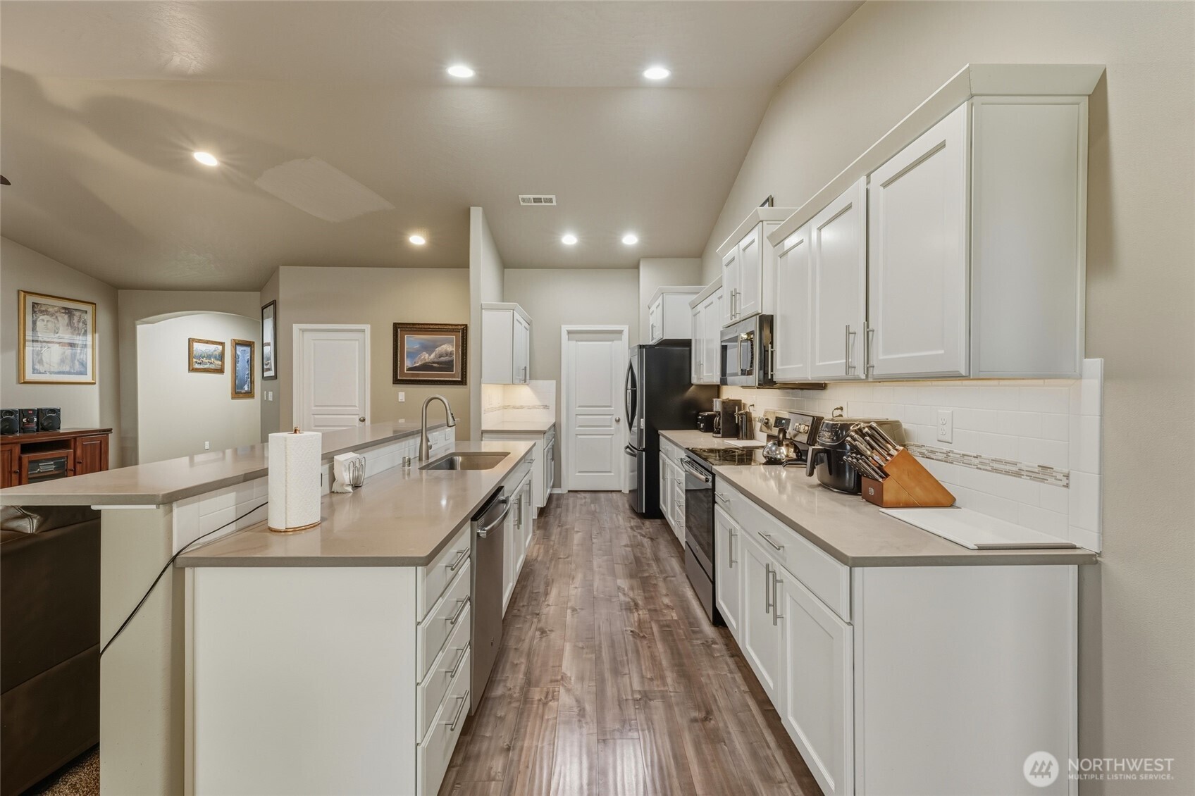 1397 Caprio Loop Walla Walla, WA 99362 - Photo 25 of 40 a kitchen with stainless steel appliances granite countertop a stove top oven a refrigerator a sink and white cabinets with wooden floor