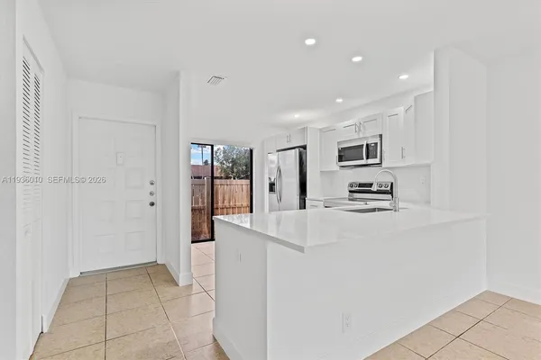 a view of kitchen with cabinets and refrigerator