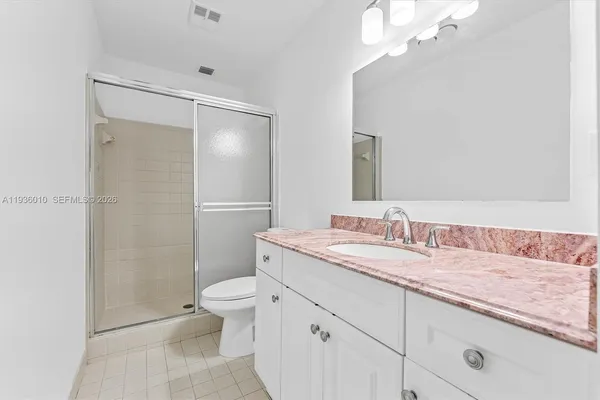 a bathroom with a granite countertop sink toilet and shower