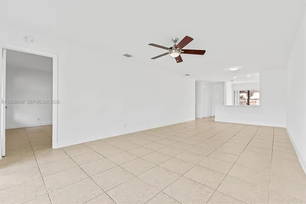 a view of an empty room and a ceiling fan