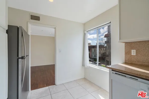 a view of a kitchen from the hallway with windows