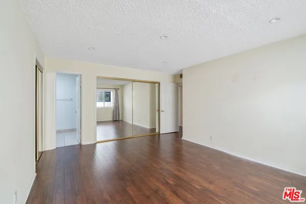 a view of a big room with wooden floor and windows