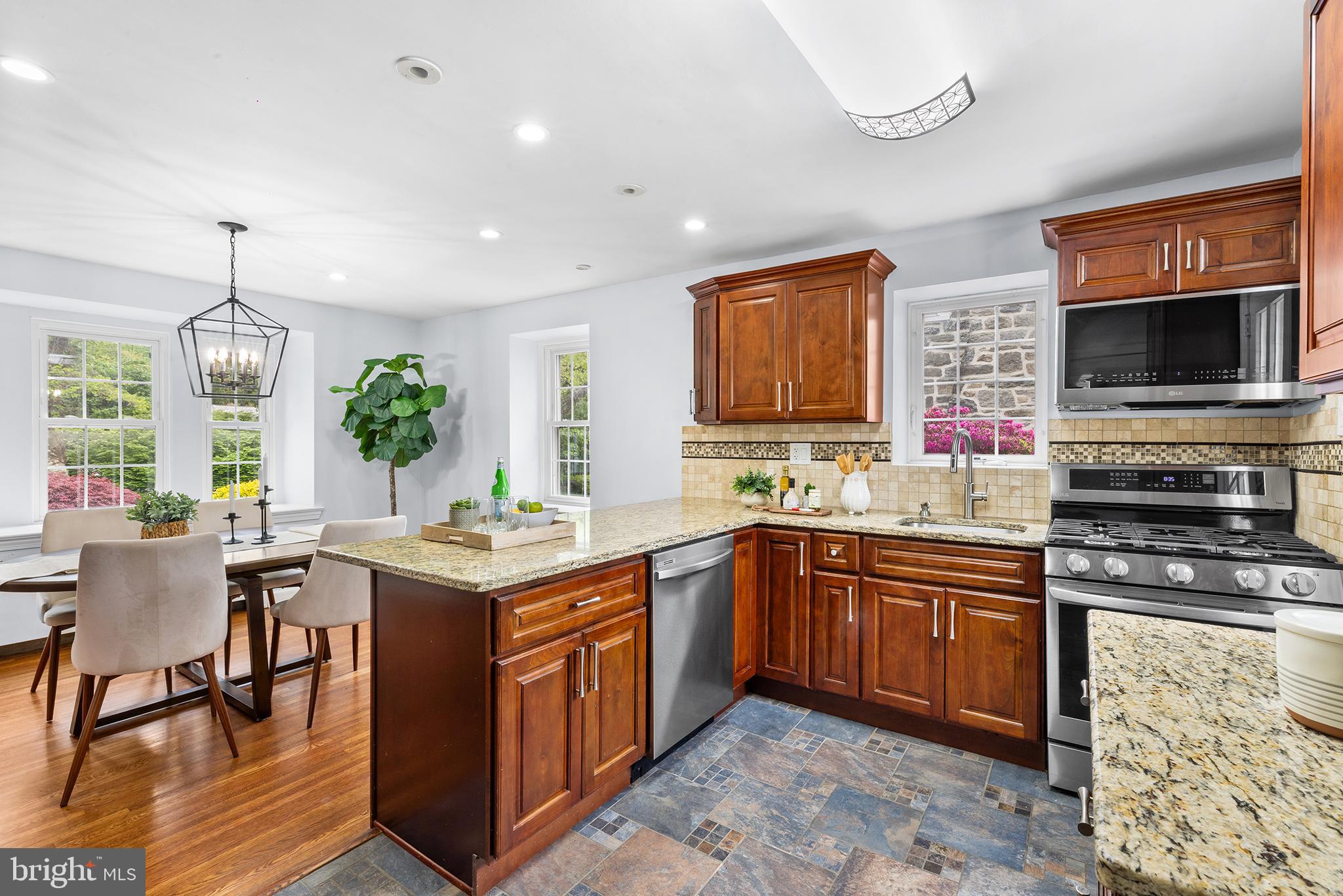 112 Rolling Road Bala Cynwyd, PA 19004 - Photo 10 of 39 a kitchen with a stove a sink a dining table and chairs