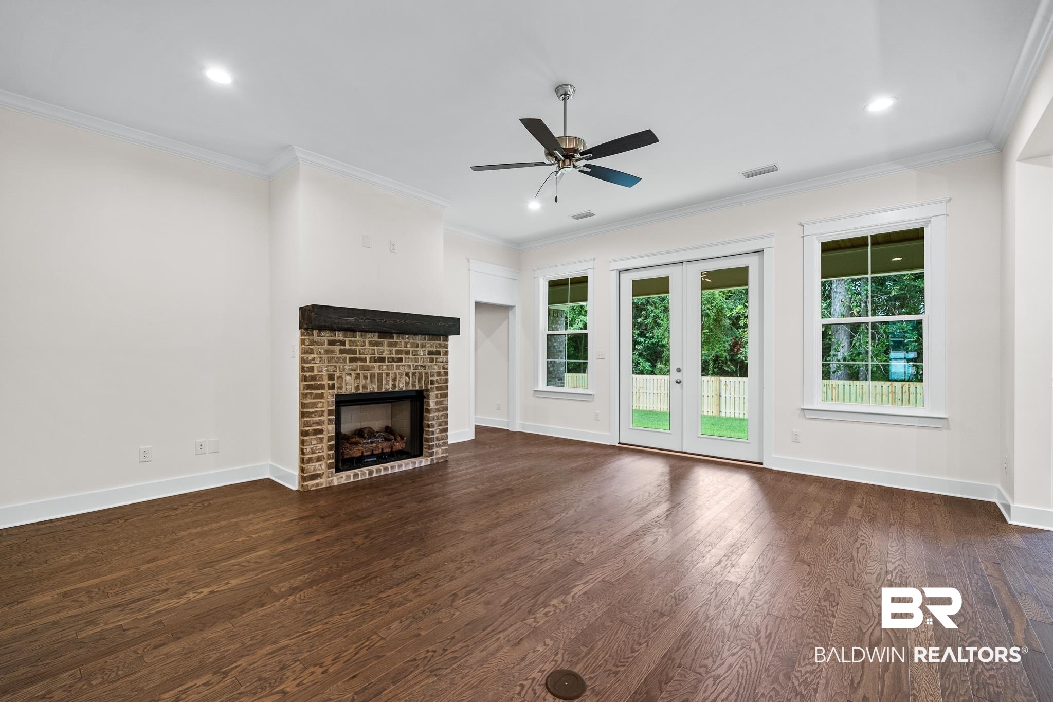 29 Signal Hill Road Daphne, AL 36527 - Photo 5 of 36 Unfurnished living room featuring ceiling fan, a fireplace, plenty of natural light, and dark hardwood / wood-style floors
