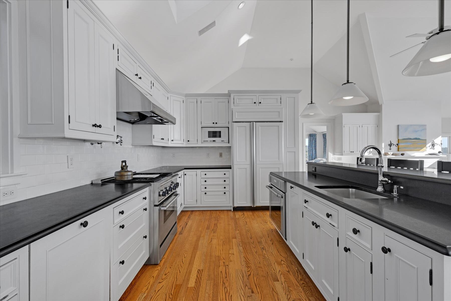 1035 Chequessett Neck Road Wellfleet, MA 02667 - Photo 11 of 86 a large kitchen with stainless steel appliances granite countertop a lot of counter space and wooden floors