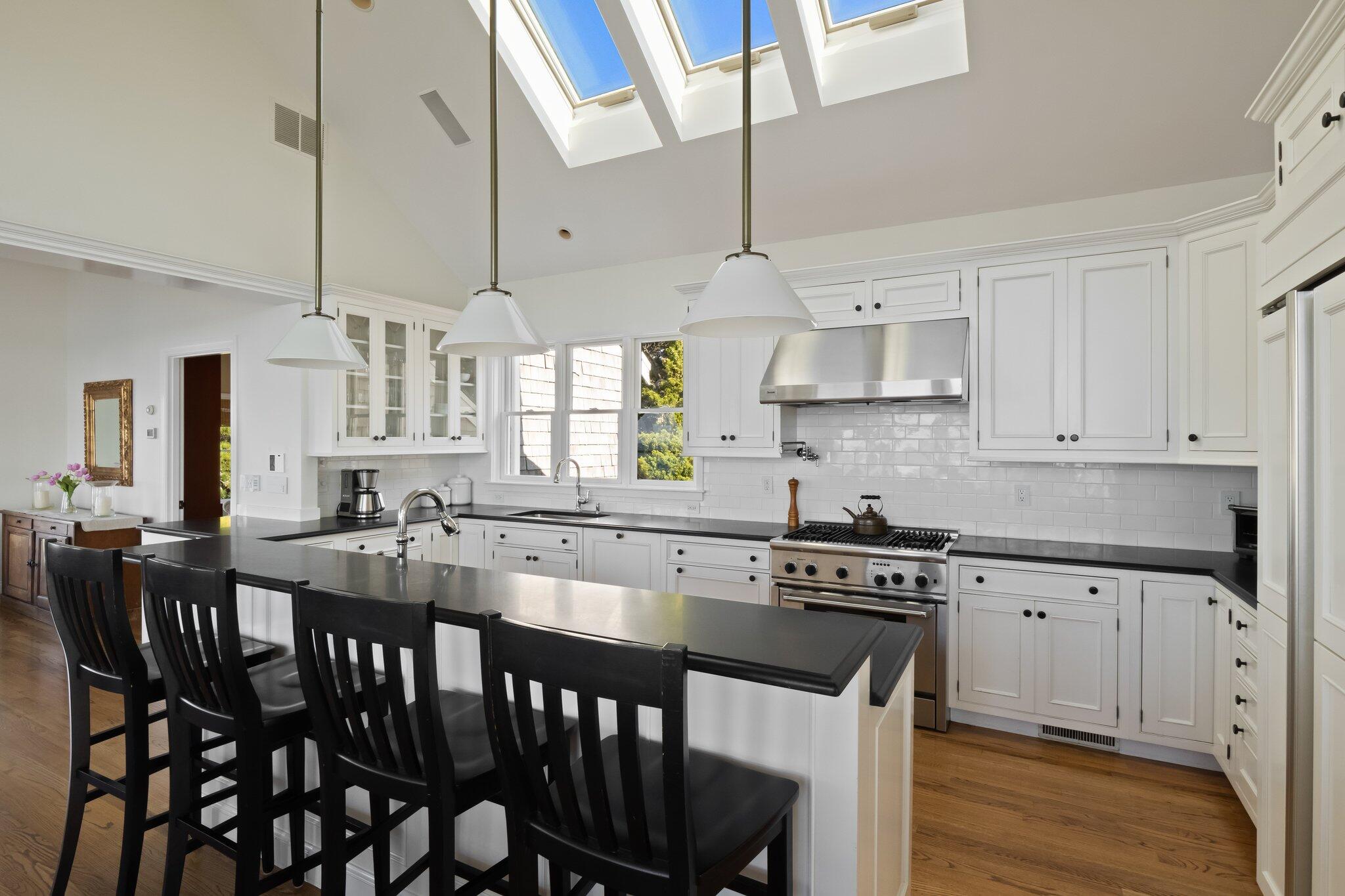 1035 Chequessett Neck Road Wellfleet, MA 02667 - Photo 12 of 86 a kitchen with stainless steel appliances granite countertop a stove a sink dishwasher a dining table and chairs with wooden floor