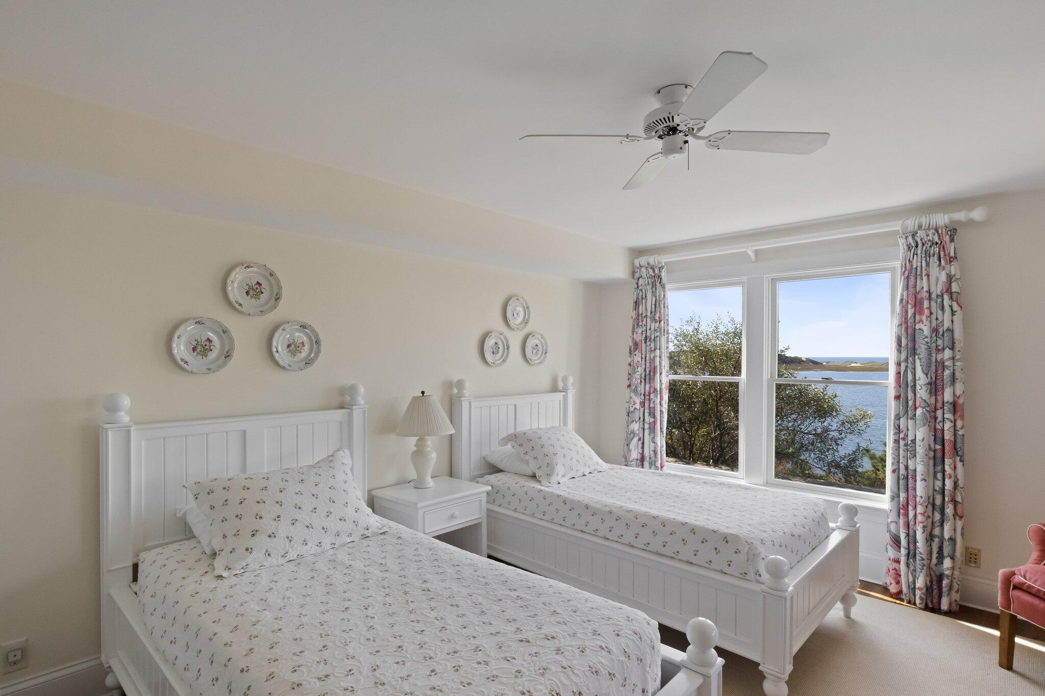 1035 Chequessett Neck Road Wellfleet, MA 02667 - Photo 48 of 86 a bedroom with a large bed and a chandelier