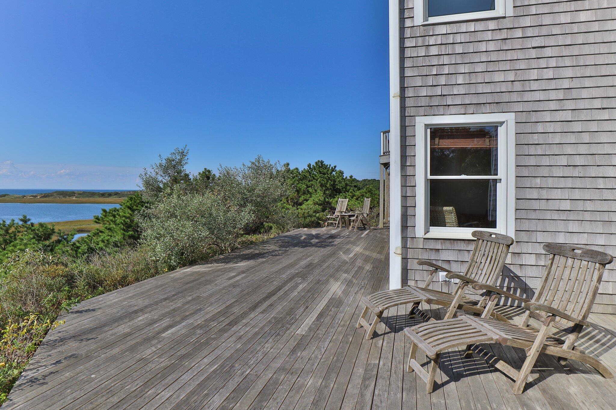 1035 Chequessett Neck Road Wellfleet, MA 02667 - Photo 67 of 86 a view of a patio with table and chairs with wooden floor and fence