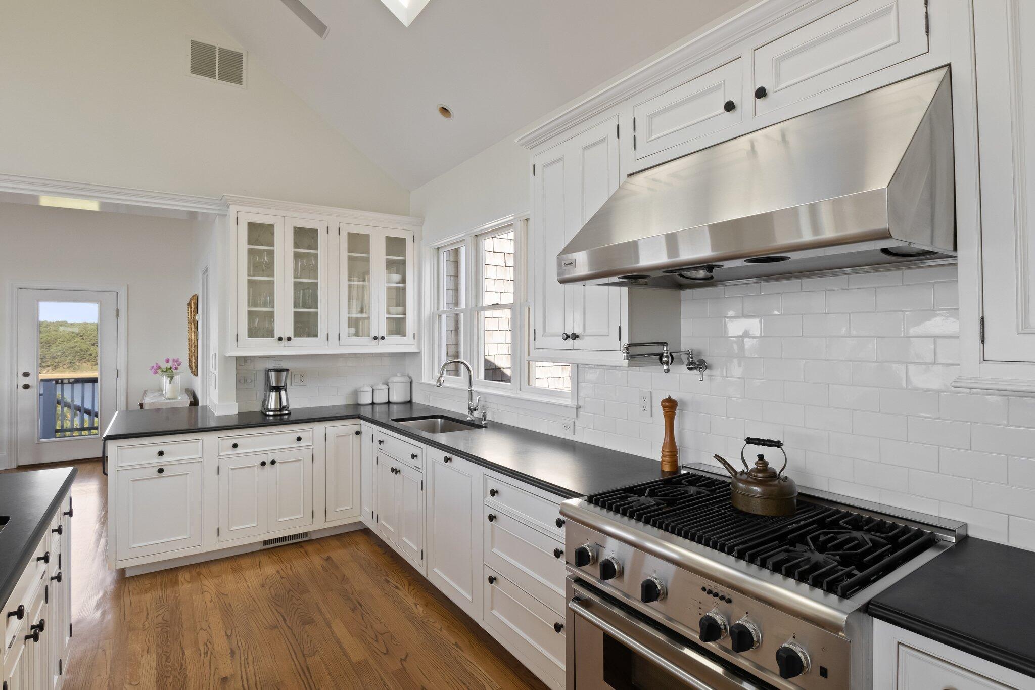 1035 Chequessett Neck Road Wellfleet, MA 02667 - Photo 9 of 86 a kitchen with stainless steel appliances a sink stove and cabinets