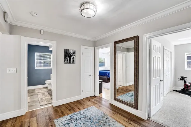 a view of a hallway with wooden floor and windows