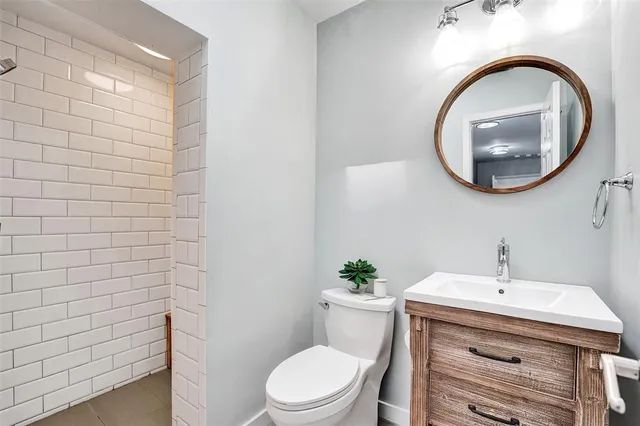 a bathroom with a sink a toilet and a mirror