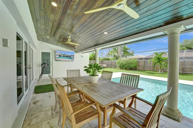 a view of a patio with a table chairs and a backyard