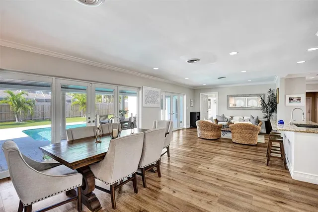 a view of a dining room with furniture large windows and wooden floor