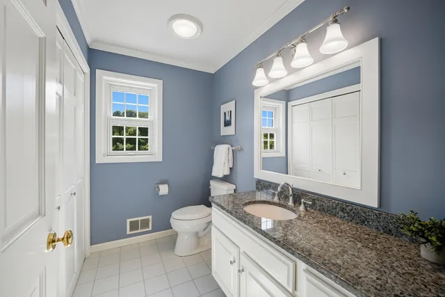a spacious bathroom with a granite countertop sink toilet and shower