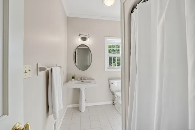 a bathroom with a toilet a sink and a mirror