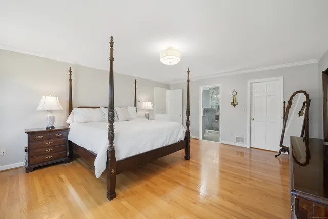 a bedroom with a bed mirror and window