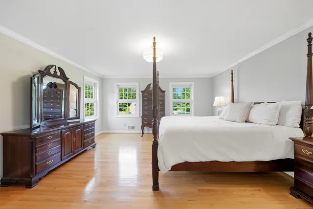 a bedroom with a large bed and a flat tv screen on a dresser