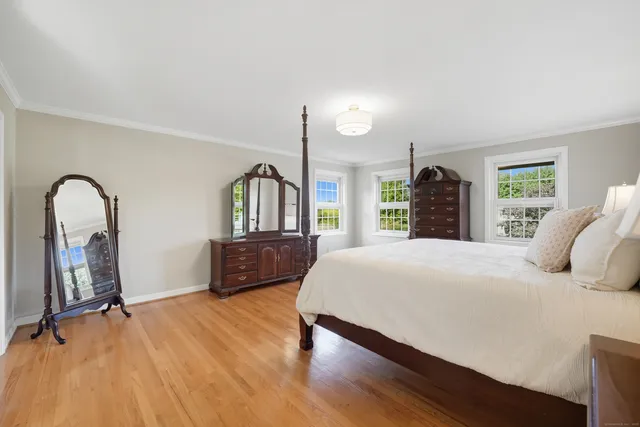 a bedroom with a bed dresser and a window