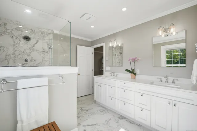 a bathroom with a double vanity sink a mirror and a shower