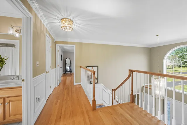 a view of hallway with wooden floor and stairs