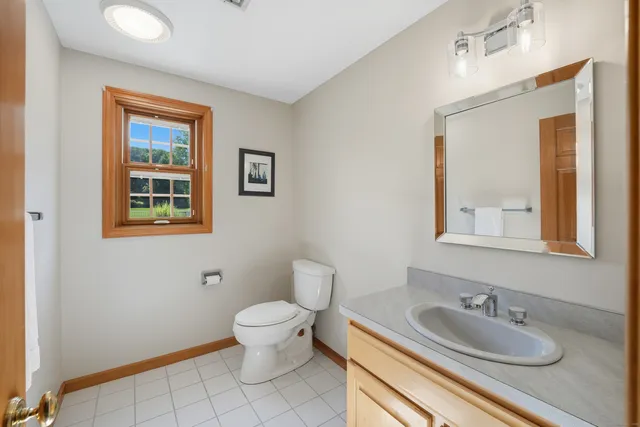 a bathroom with a granite countertop toilet a sink and mirror