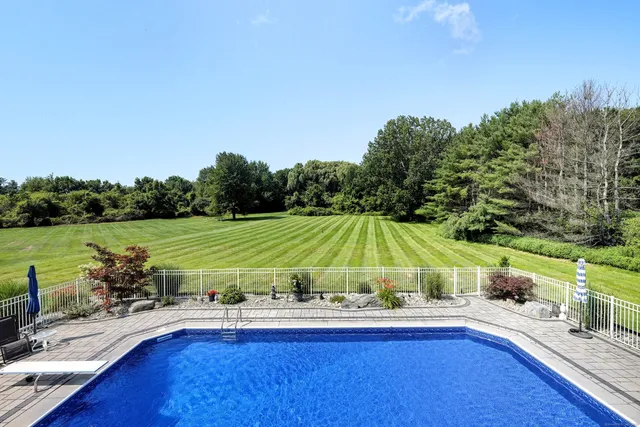 a view of a swimming pool and lounge chairs in the patio