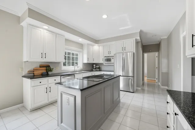 a kitchen with stainless steel appliances granite countertop a stove a sink and a refrigerator