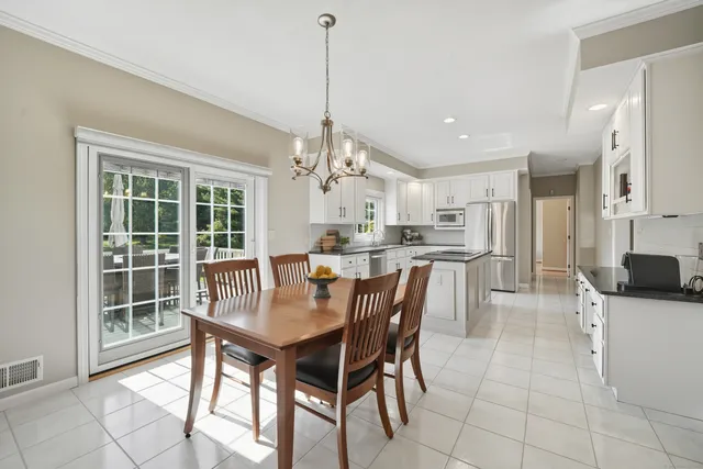 a view of a dining room and livingroom with furniture wooden floor a chandelier