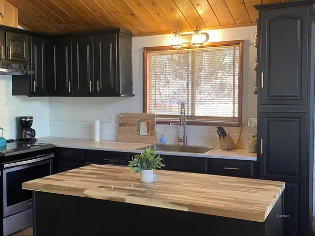 a kitchen with a stove a sink and a cabinets