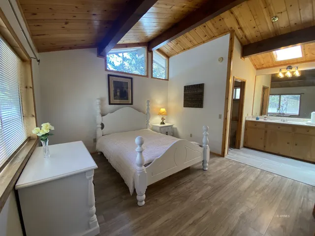 a bedroom with a bed and a flat tv screen on dresser